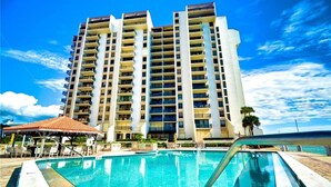A high-rise hotel with a swimming pool in the foreground. - Beautiful Penthouse Style on Clearwater Beach (Clearwater)