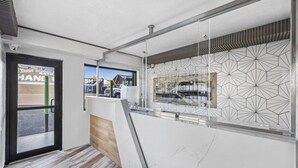 A modern interior with a wooden floor, a glass partition, and a geometric patterned wall. - Hotel Opus Bronx (Bronx)