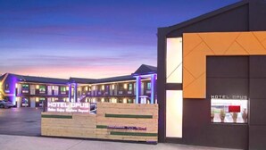 A hotel with a modern design, featuring a prominent entrance with a wooden facade and illuminated signage. - Hotel Opus Bronx (Bronx)