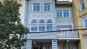 Un edificio de dos pisos con balcón y puerta de garaje.