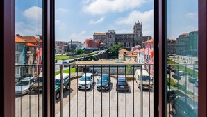 Vista de un edificio histórico con una torre destacada, rodeado de edificios modernos y automóviles estacionados.