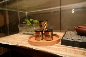 A display of tea tins on a wooden tray in a glass case.