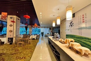 Een modern restaurantinterieur met een lange toonbank, tafels en rode lantaarns.