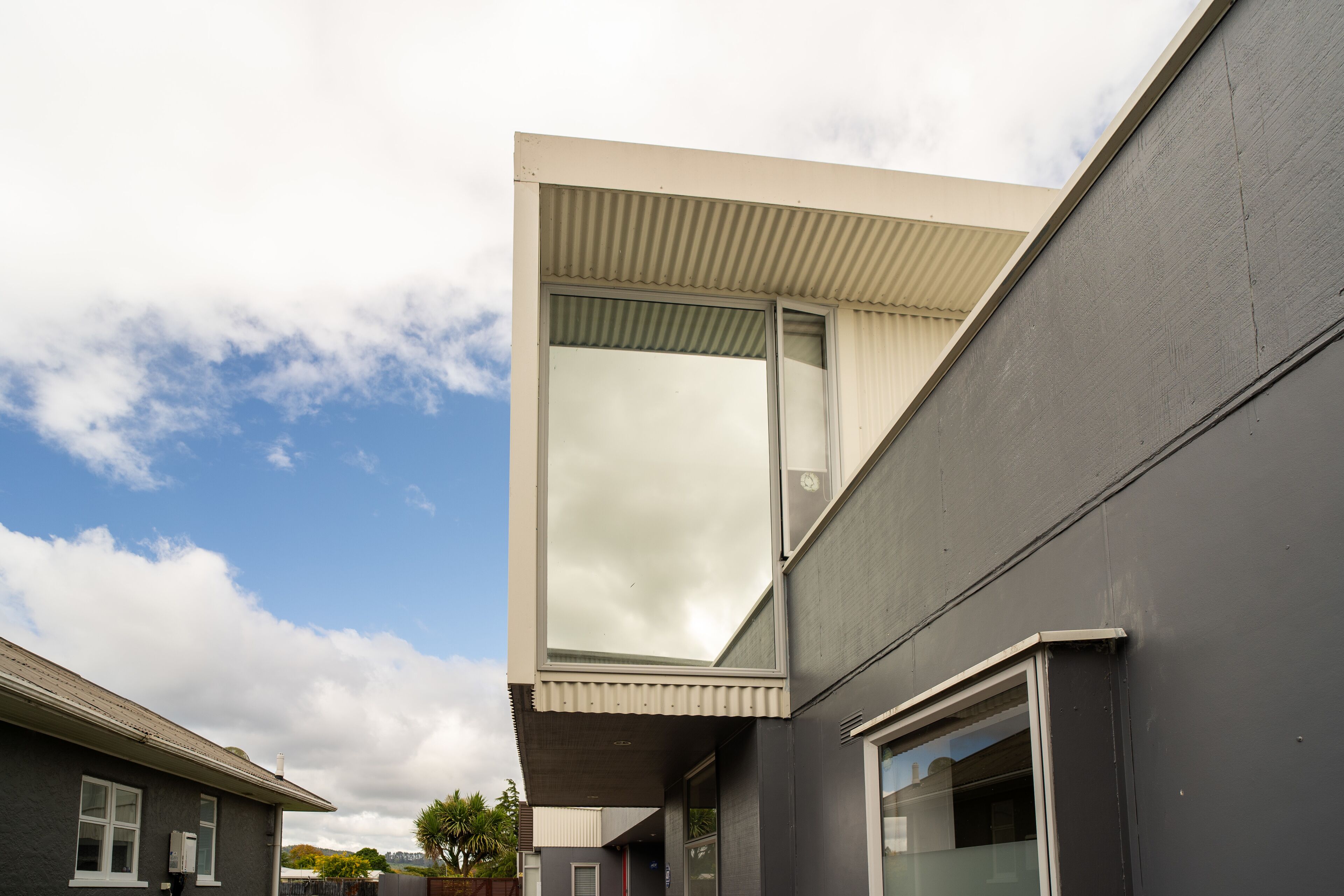 Un bâtiment moderne doté d’une grande fenêtre et d’un toit en pente.