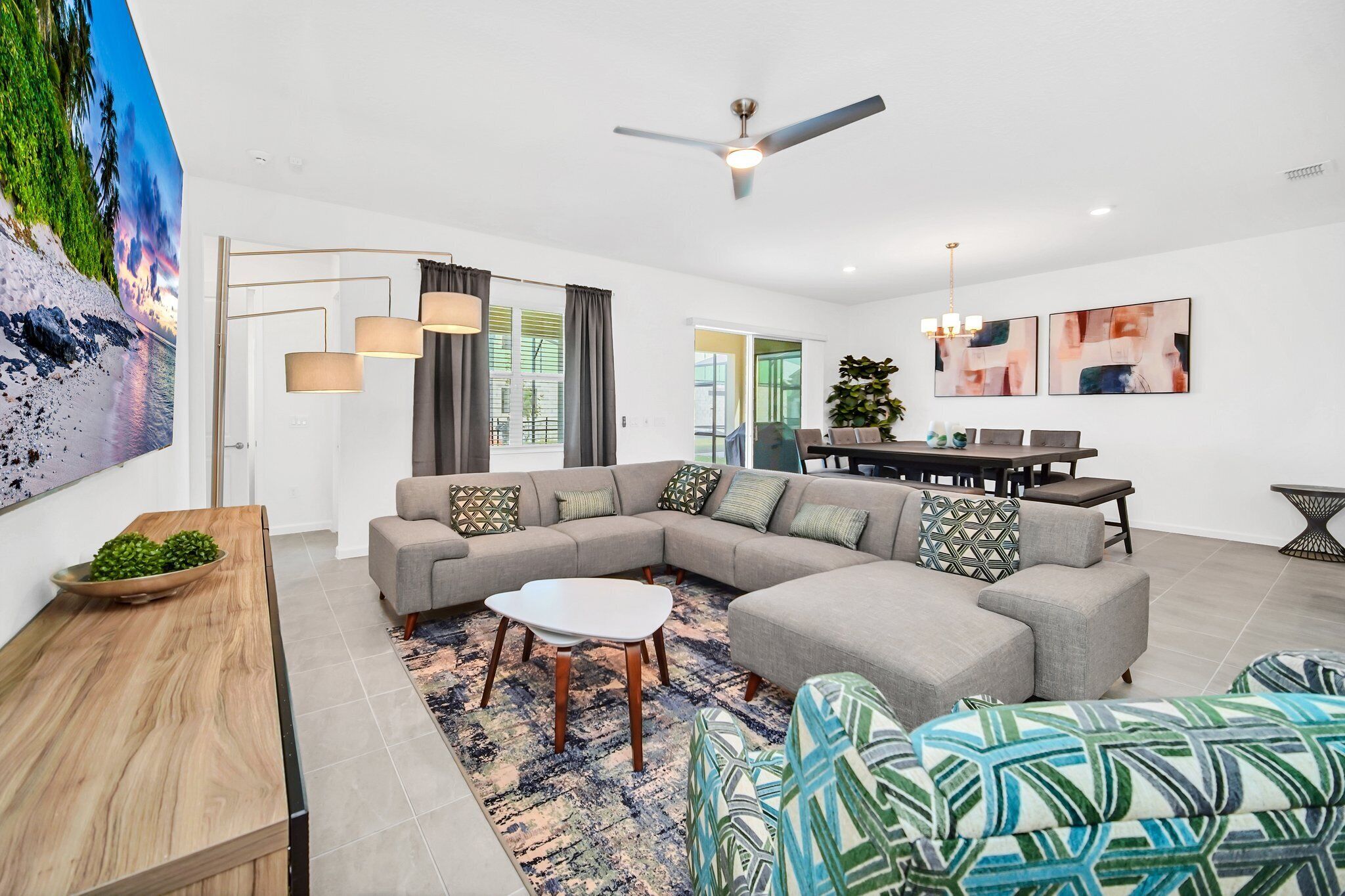 A modern living room with a sectional sofa, a coffee table, and a dining area with a table and chairs.