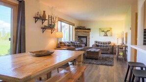 Una sala de estar acogedora con chimenea, una mesa de comedor de madera y un sofá.