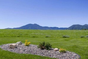 A landscaped garden with a circular stone border, a small bush, and a rock. - Villa South- Hot Tub- Mountain Views- Pet Friendly (Red Lodge)