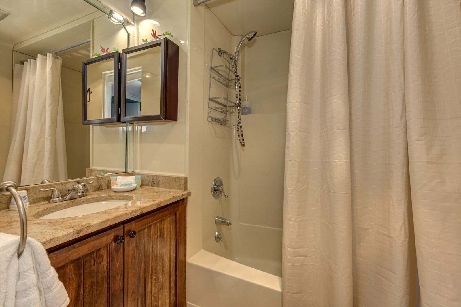 A bathroom with a double sink vanity, a shower with a glass door, and a bathtub.