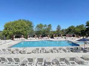 Ein Poolbereich mit Liegestühlen und Cabanas.