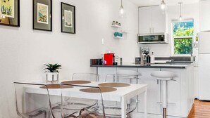 A modern kitchen with white cabinets, a central island, and pendant lighting. - 08 Lodge, Downtown, AC, Ground Floor, Hood River! (Hood River)
