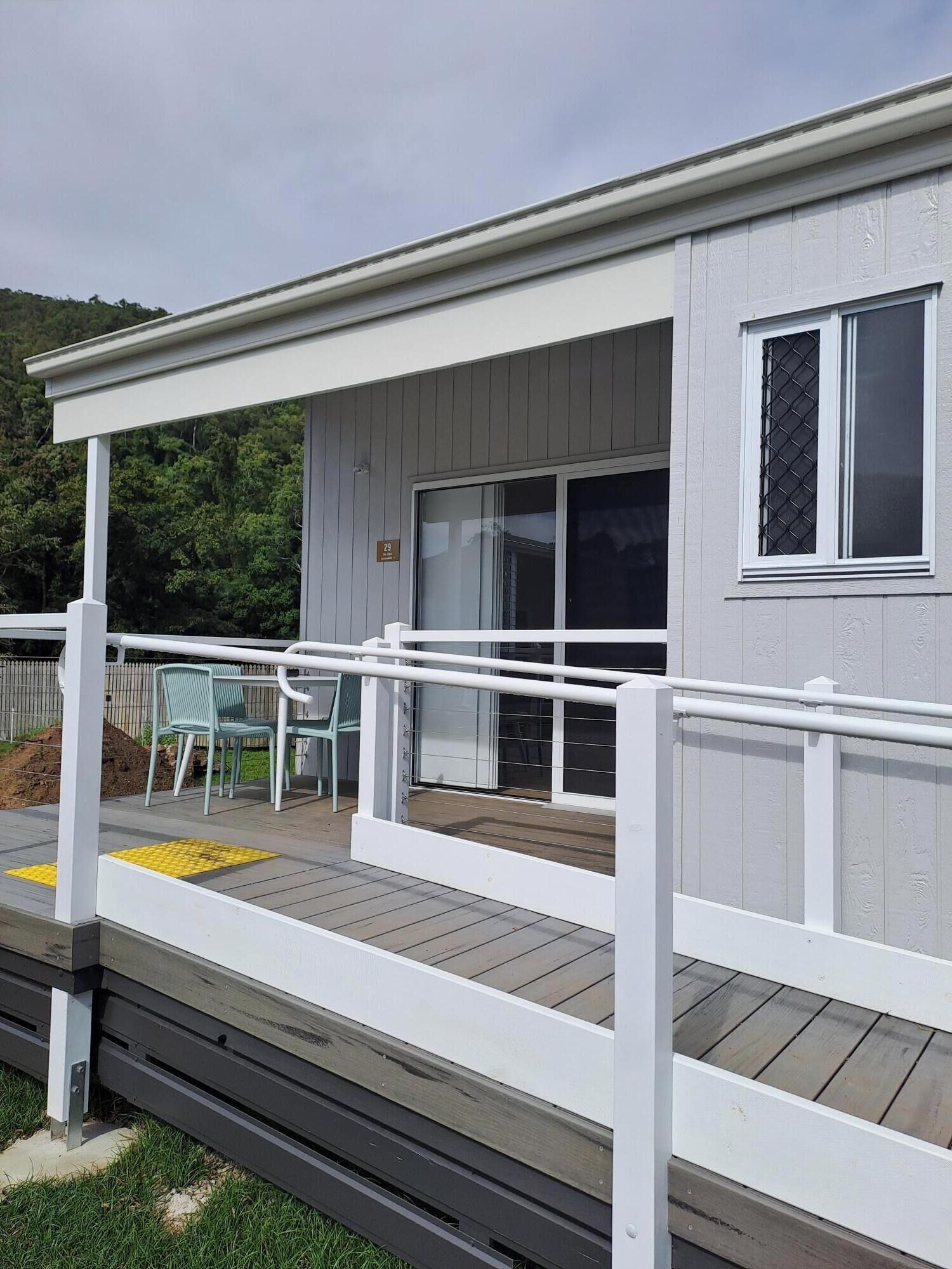 A single-story building with a covered porch, a sliding glass door, and a small window with a security screen.