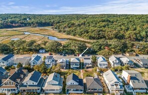 A residential area with houses arranged in rows, a river, and a forested hill in the background. - Adorable Beach house with lots of outdoor space and steps to Long Beach!  (Rockport)