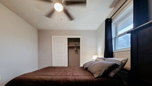 A bedroom with a bed, a ceiling fan, a window with curtains, and a door leading to a closet. - Central Stay! Near UK/Downtown/Campus. (Lexington)