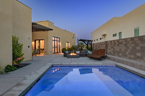 A swimming pool with a fire pit, outdoor seating, and a patio area. - Paradise Retreat at Copper Rock! (Hurricane)