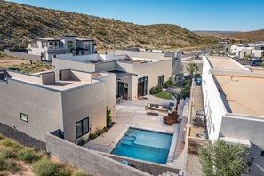 A modern residential complex with a swimming pool, outdoor seating, and a hilly backdrop. - Paradise Retreat at Copper Rock! (Hurricane)