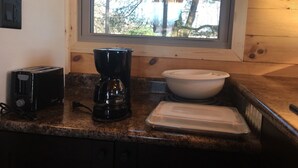 A kitchen with a toaster, coffee maker, and a white bowl on the counter. - Couples getaway TINY Log Cabin by the pine trees (Goshen)