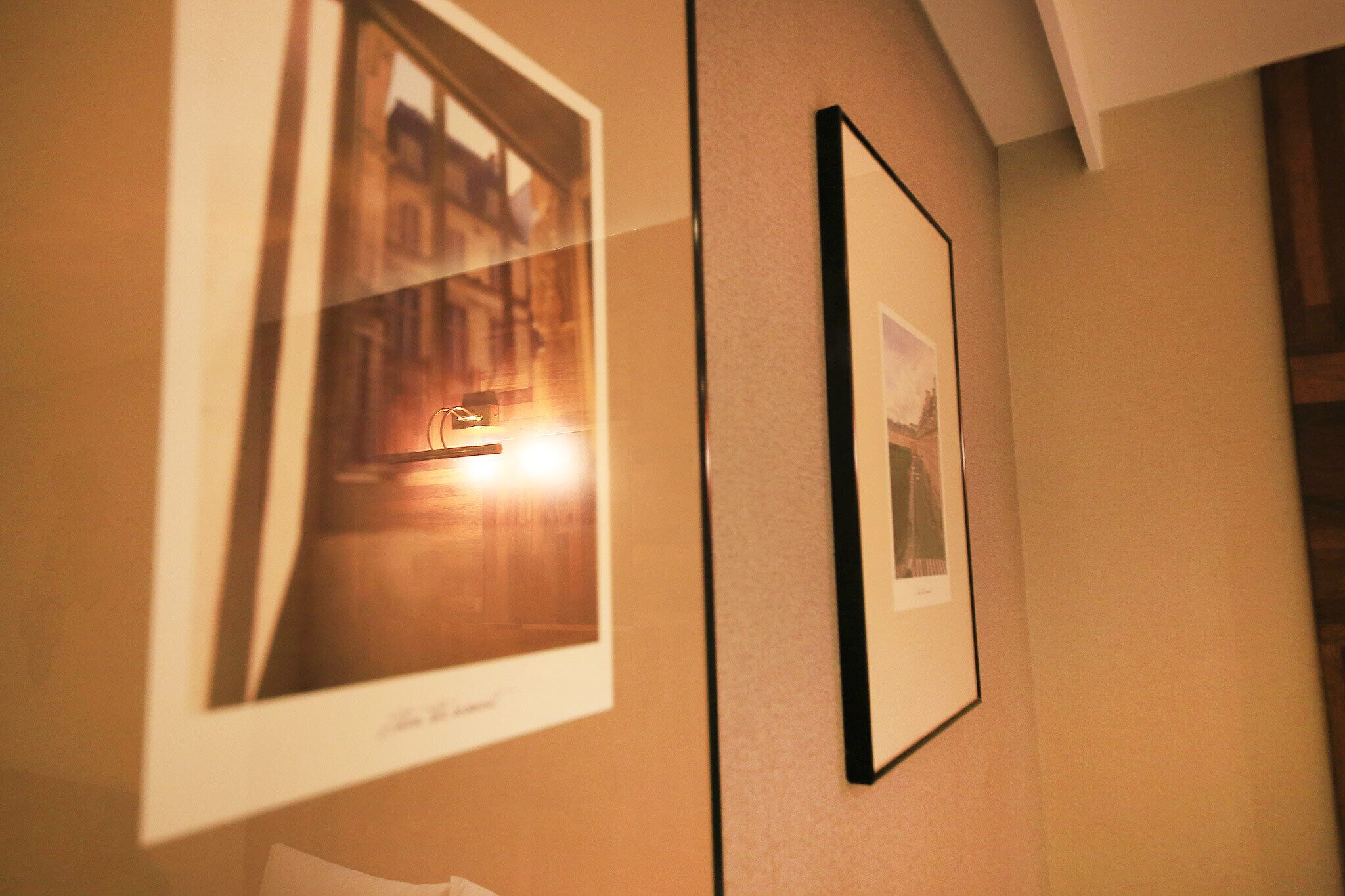 Framed photographs on a wall, possibly in a hotel or similar establishment.