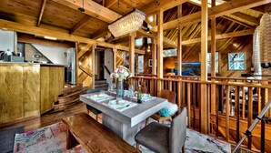 Un intérieur spacieux en bois, comprenant un coin repas, une cuisine et une grande fenêtre.