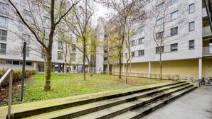 A multi-story residential building with a central courtyard, steps leading to a lower level, and a bike parking area. - Modern Leopoldstadt 1BR w/ Balcony & Elevator, nr metro U2, by Blueground (Vienna)