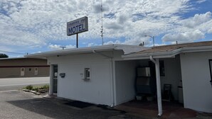 A small, single-story motel with a Country Inn sign, a small entrance, and a visible parking area. - Country Inn-Giddings (Giddings)