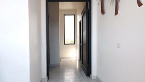 A hallway with a door leading to a bright room. - New Town Condo Casamar 2 near the beach (Puerto Peñasco)