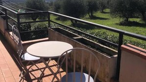 A balcony with a table and chairs, overlooking a scenic landscape with trees and distant hills. - Beautiful Lux Apartment Chianti Firenze Area Italy (Barberino Tavarnelle)