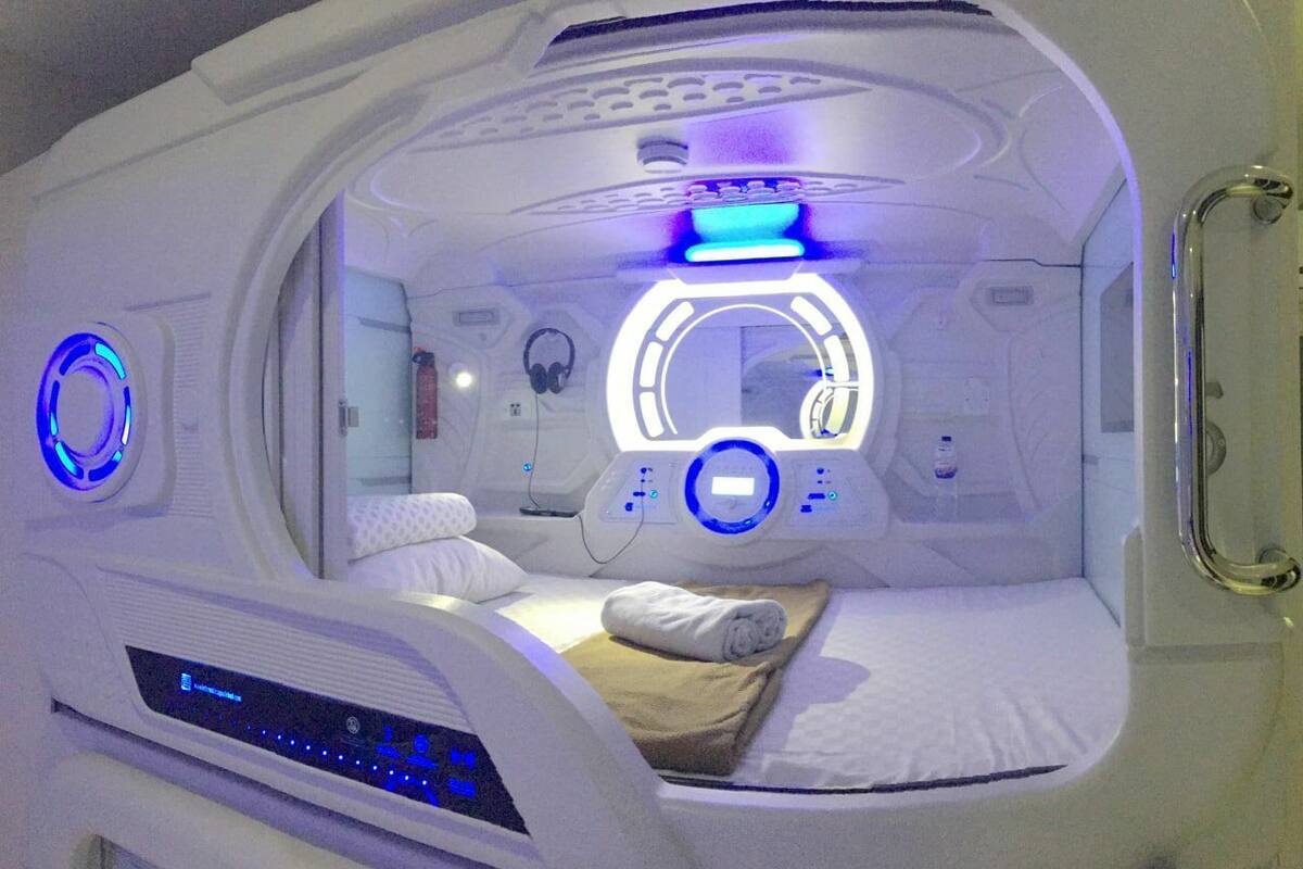 A medical imaging room with a bed, control panels, and a circular light fixture.