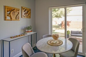 A dining area with a round table, chairs, a vase with flowers, and two framed artworks on the wall. - Comfy Cute Condo - entire home (Boulder)