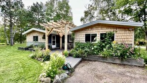 Une maison à deux étages avec un patio couvert et un jardin.