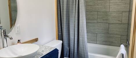 Ein Badezimmer mit einem weißen Waschbecken, einer Toilette und einer Badewanne.