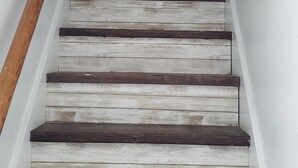 Una escalera con escalones y barandal de madera.