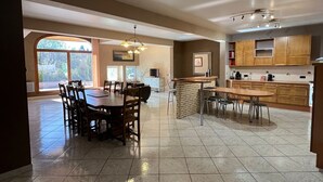 A spacious kitchen with a dining area, large windows, and a tiled floor. - Country property with covered terrace and large swimming pool (Charcier)