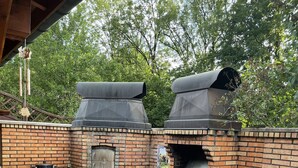 A brick outdoor kitchen with two large chimneys, a built-in oven, and a wooden deck. - Country property with covered terrace and large swimming pool (Charcier)