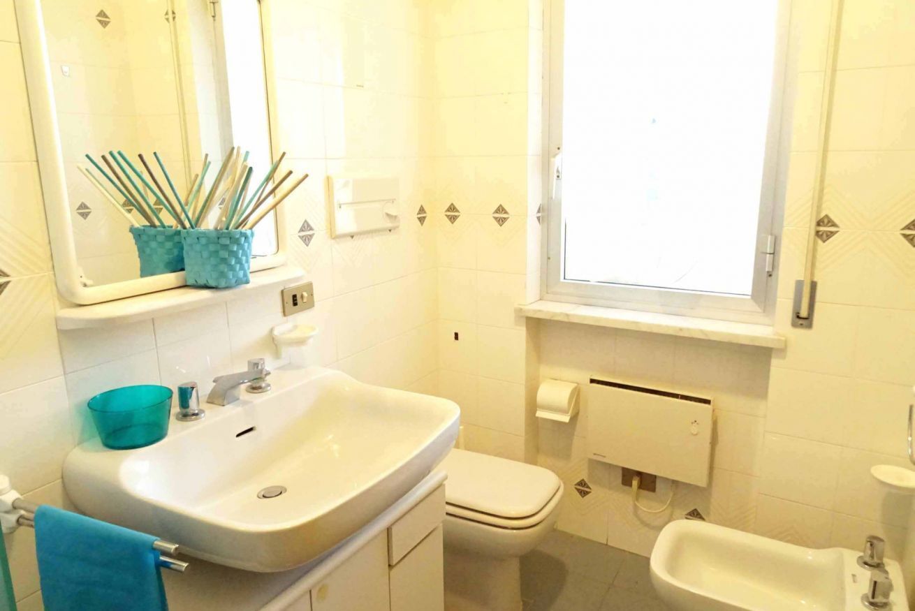 Une salle de bain équipée d’un lavabo, de toilettes, d’un bidet et d’une fenêtre.