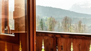 A wooden cabin with a view of a forested mountain range. - Vacation Home "Dünser" with Mountain View, on a sunny slope. (Bizau)