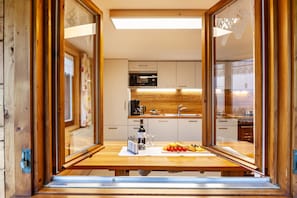 A modern kitchen with wooden cabinets, a stainless steel sink, and a breakfast setup on the counter. - Vacation Home "Dünser" with Mountain View, on a sunny slope. (Bizau)