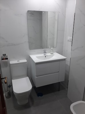 A bathroom with a toilet, sink, and mirror. - Centrally located apartment in Conil Pepa's House (Conil)