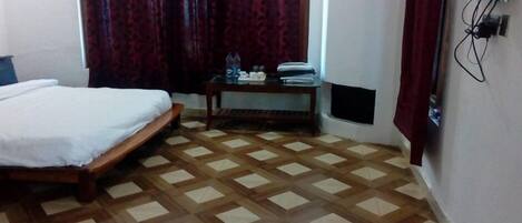 A room with a bed, a small table with toiletries, and a patterned floor.