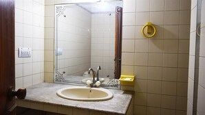 A bathroom with a sink, mirror, and toilet. - Shamrock Hotel (Lahore)