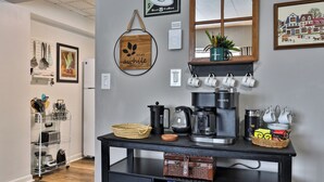 A kitchen counter with coffee-making equipment, a basket of bread, and a coffee mug. - The Hideaway Retreat at Mountain Green 1 BR/1 BA Condo, Steps to the Mountain, Amenities. (Killington)