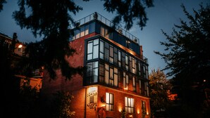 A modern building with multiple windows and balconies, surrounded by trees. - Address Boutique Hotel (Tbilisi)