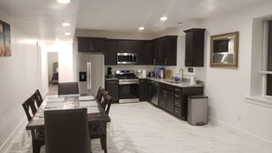 Una cocina moderna con gabinetes oscuros, electrodomésticos de acero inoxidable y encimera de mármol.