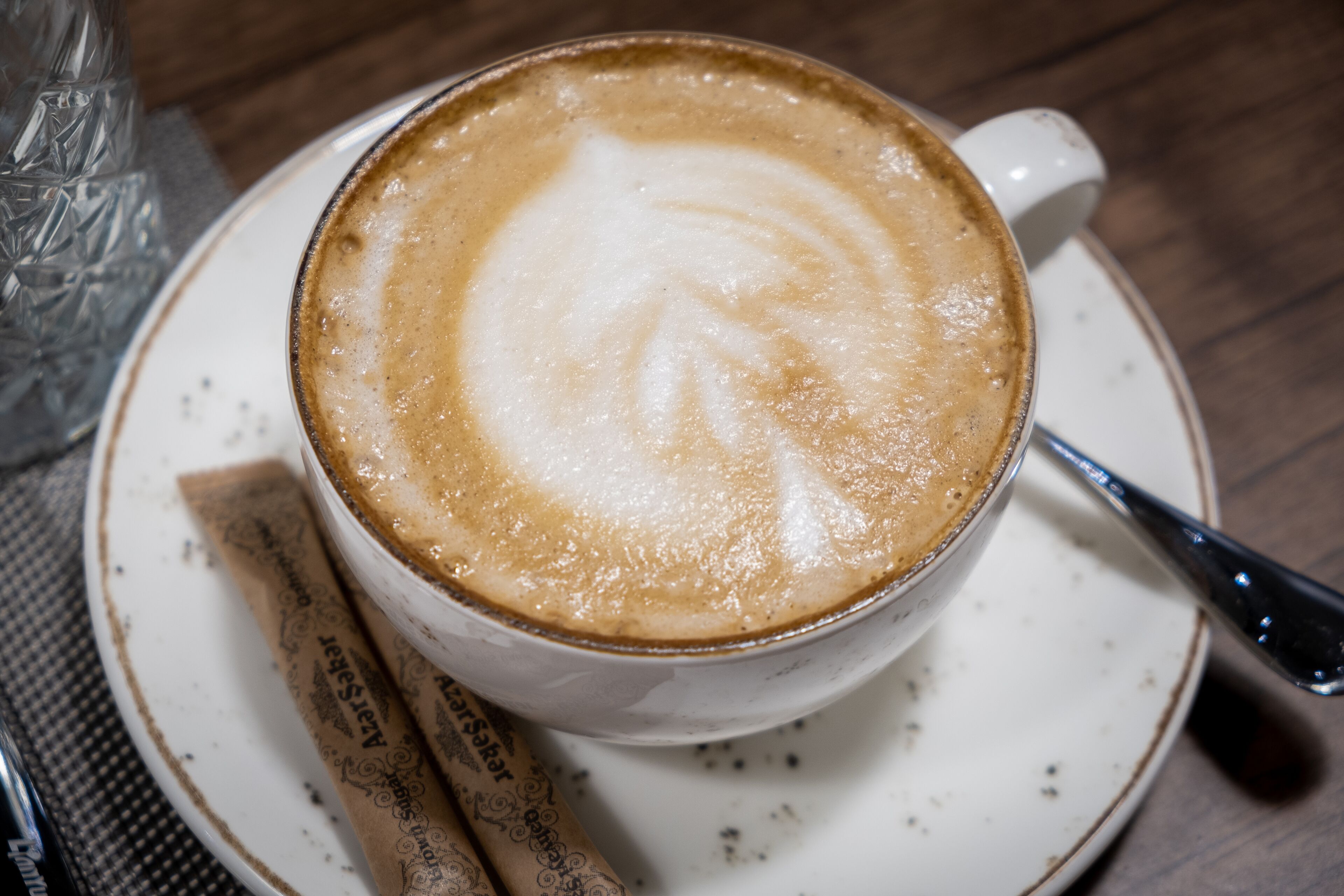 A cup of coffee with latte art on a saucer.
