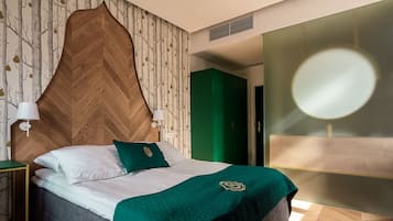 A modern bedroom with a wooden headboard, a green accent wall, and a large mirror.