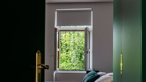 A bedroom with a bed, a window, and a door. - HOTEL STARKL HERITAGE & UNIQUE (Bled)