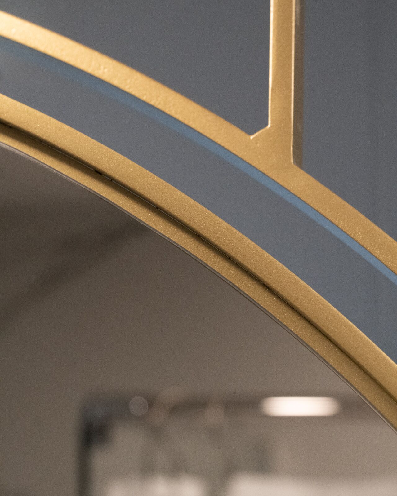 Et nærbillede af en metallisk ramme med et geometrisk design, sandsynligvis en del af et vindue eller en dør.