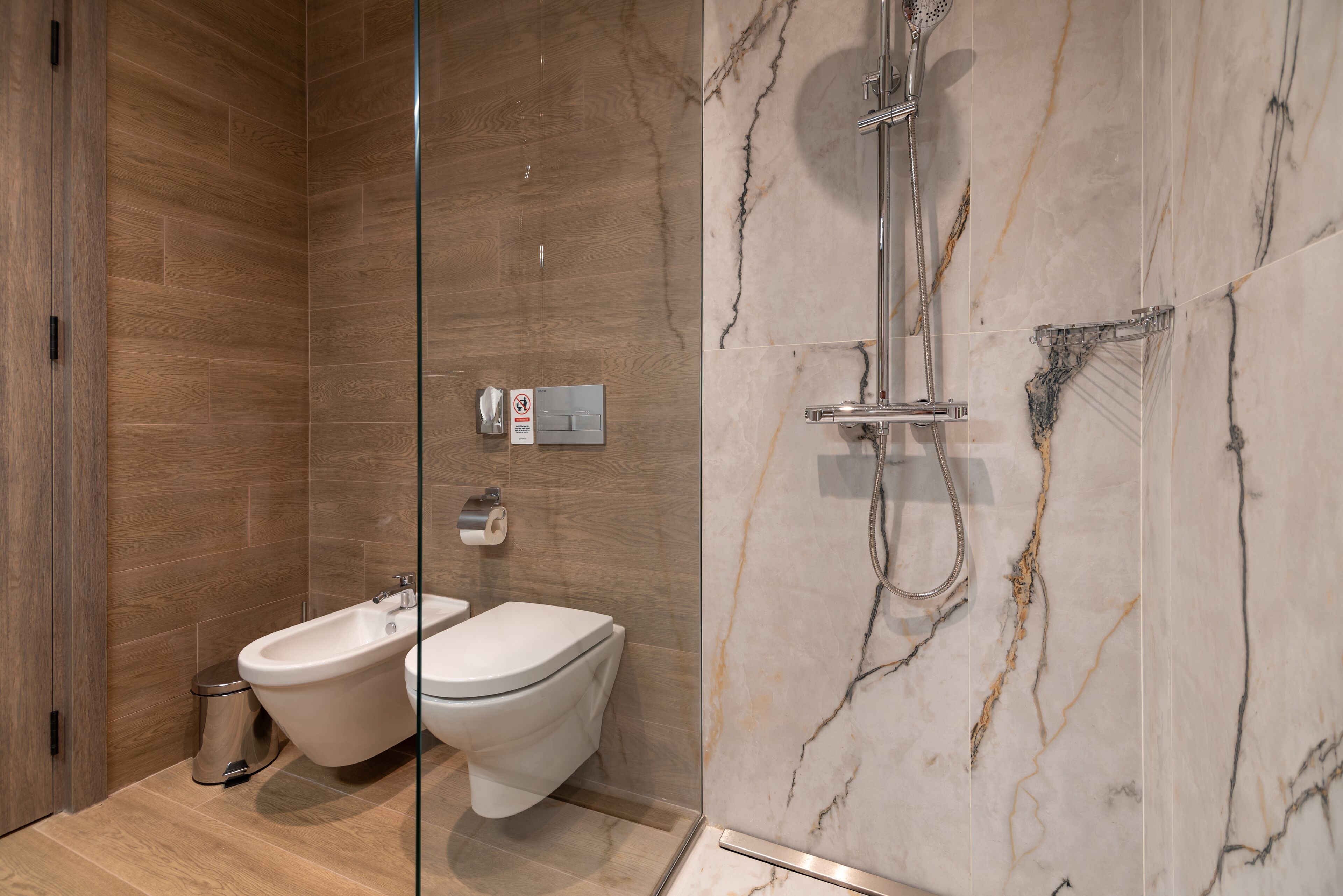 Ein modernes Badezimmer mit einem Bidet, WC und einer Duschkabine.
