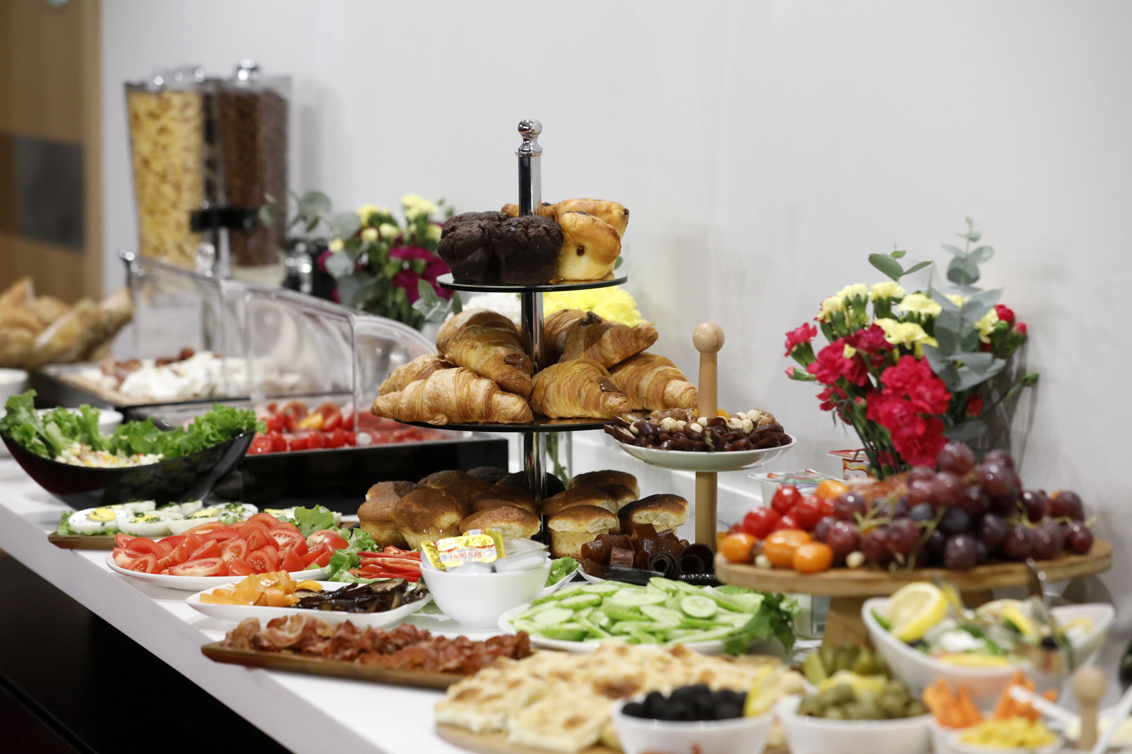 Un buffet proposant une variété de plats, notamment des pâtisseries, des salades et des fruits.