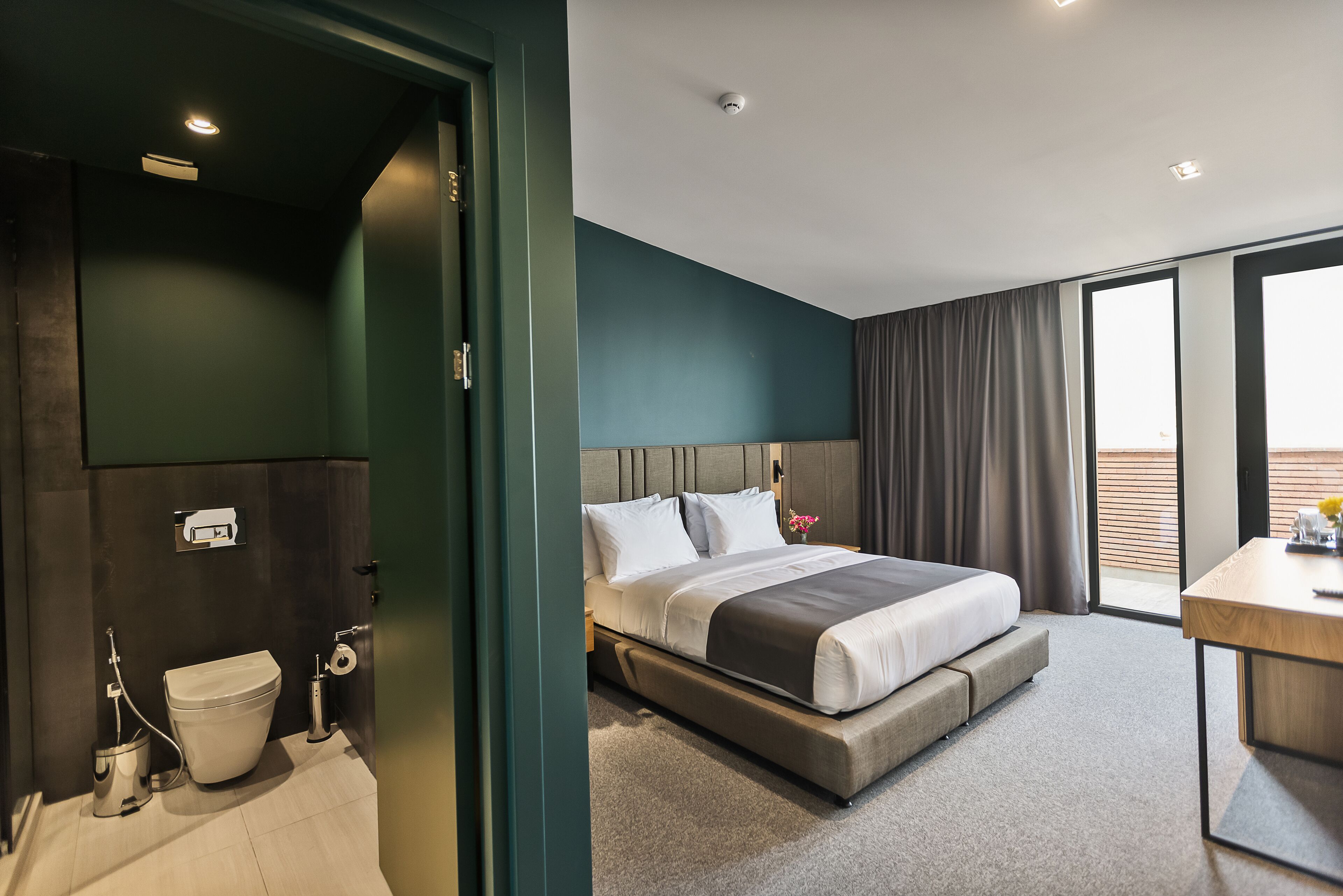 Une chambre d’hôtel moderne équipée d’un lit, d’un bureau et d’une salle de bain.