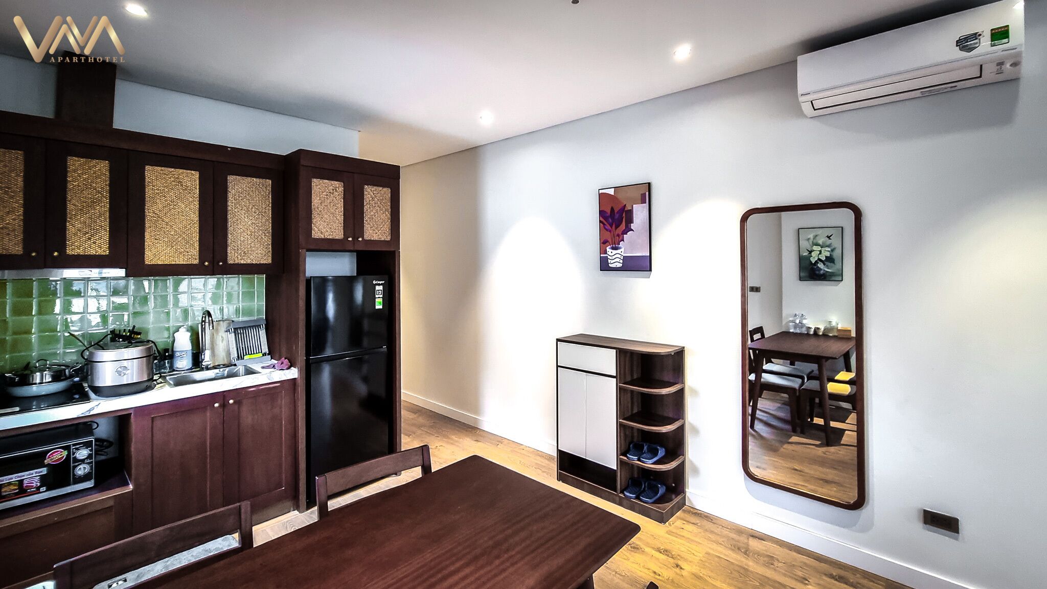 A modern kitchen with dark wooden cabinets, a black refrigerator, and a green tiled backsplash.